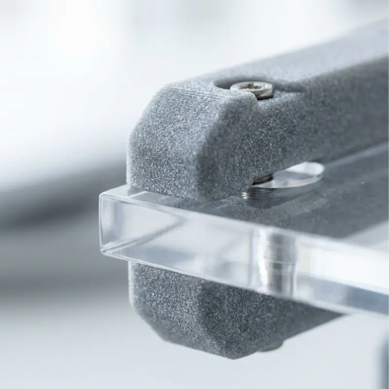 Close-up of 3D printed nylon fixture connecting clear acrylic panel